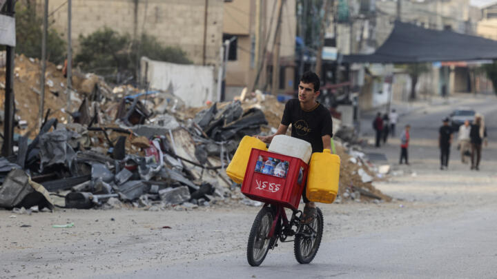 A young man transports jerricans of water on a bicycle in Rafah in the southern Gaza Strip October 22, 2023.